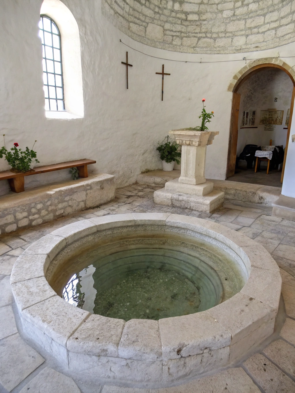 Still water in a pale stone font, one sheet of daylight across it